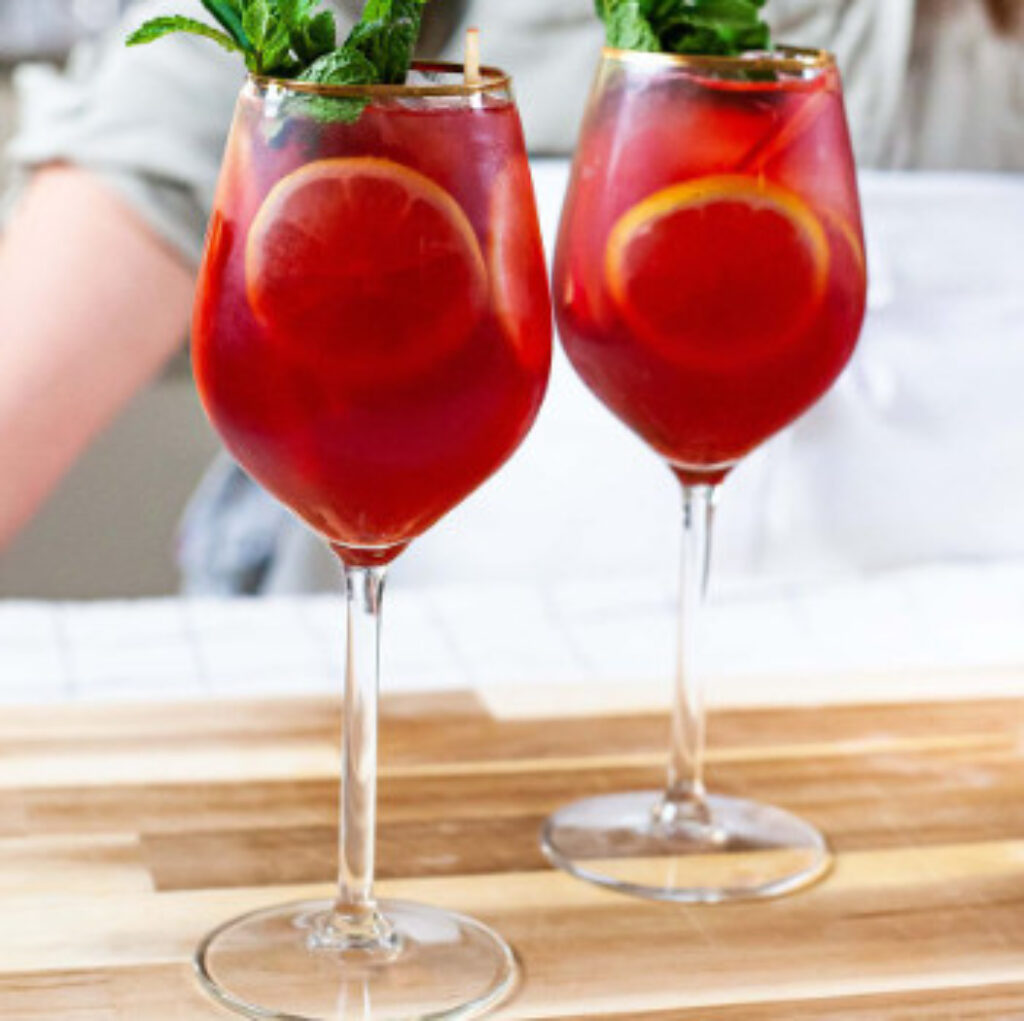 Kir Royale sangria cocktail with raspberries, blood orange slices and mint
