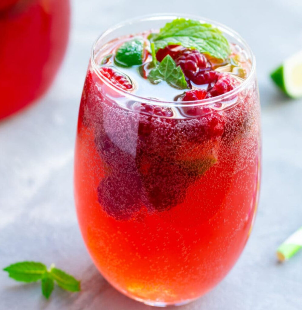 Raspberry amaretto cocktail in sugar rimmed glass with raspberries